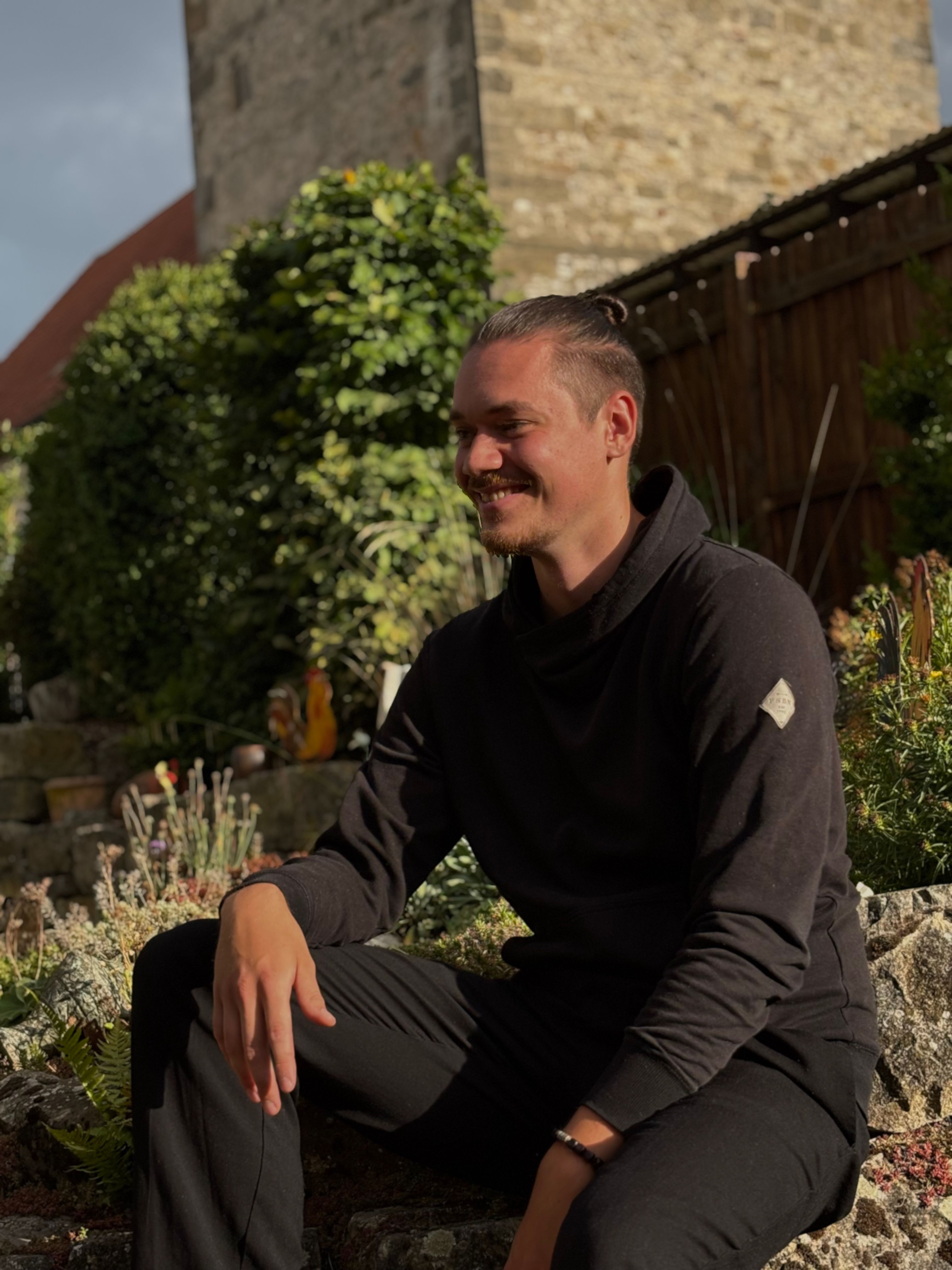 Luca Ahrens auf einer Mauer sitzend