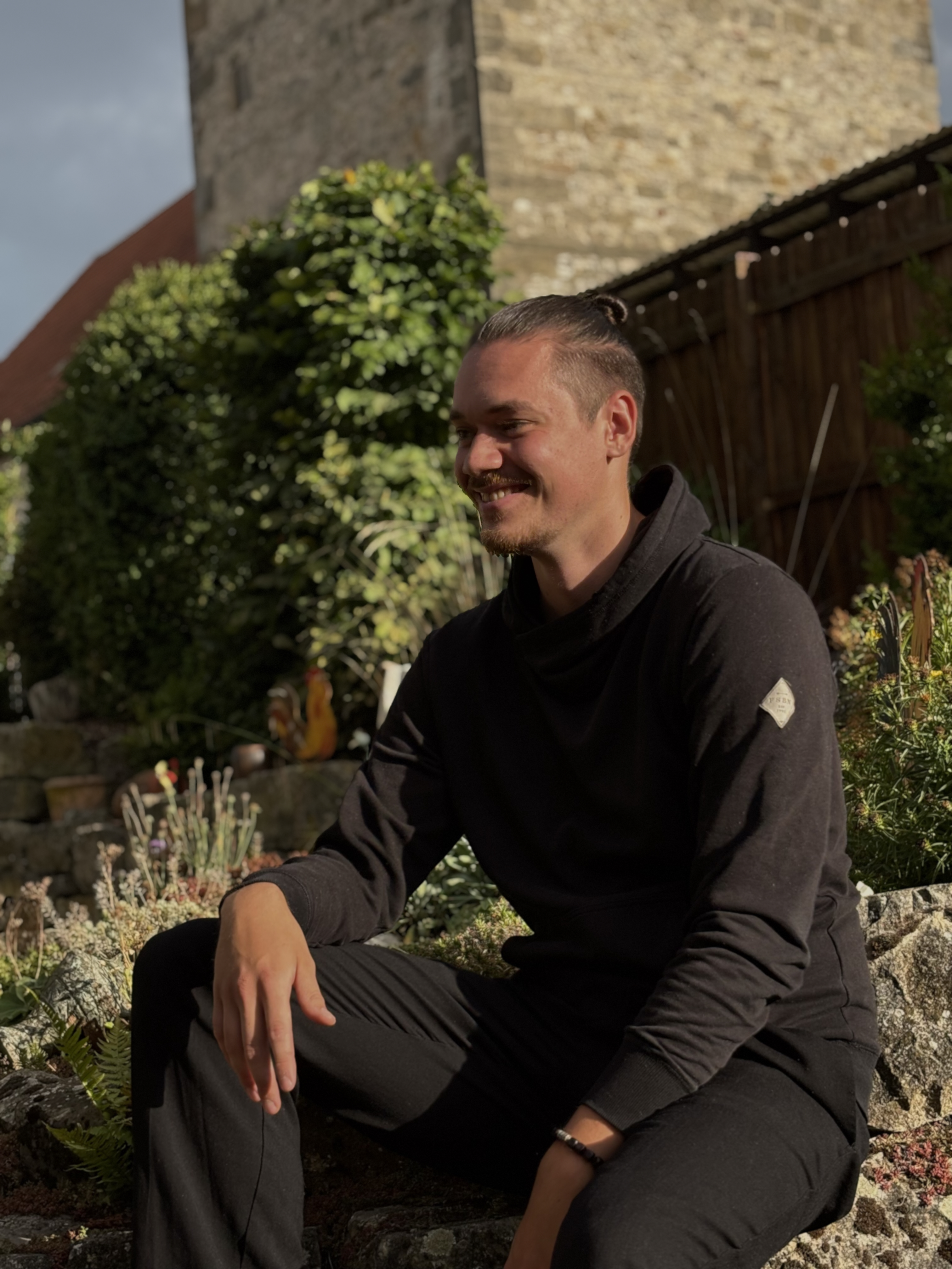 Luca Ahrens auf einer Mauer sitzend